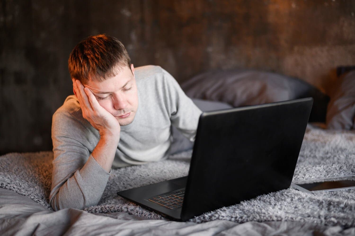 Man falling asleep in front of his laptop